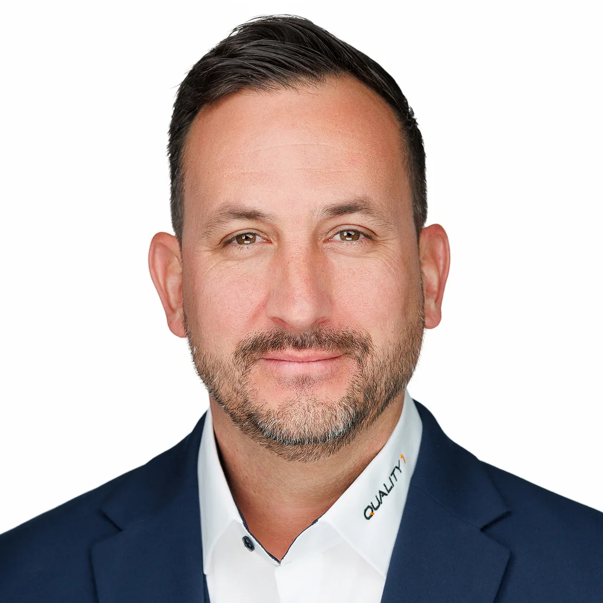 Marc Kessler wechselt von der Position des CEO in den Verwaltungsrat von Quality1. Porträt von Marc Kessler. Er trägt ein dunkles Sakko und ein weisses Hemd mit der Aufschrift Quality1 am Kragen.